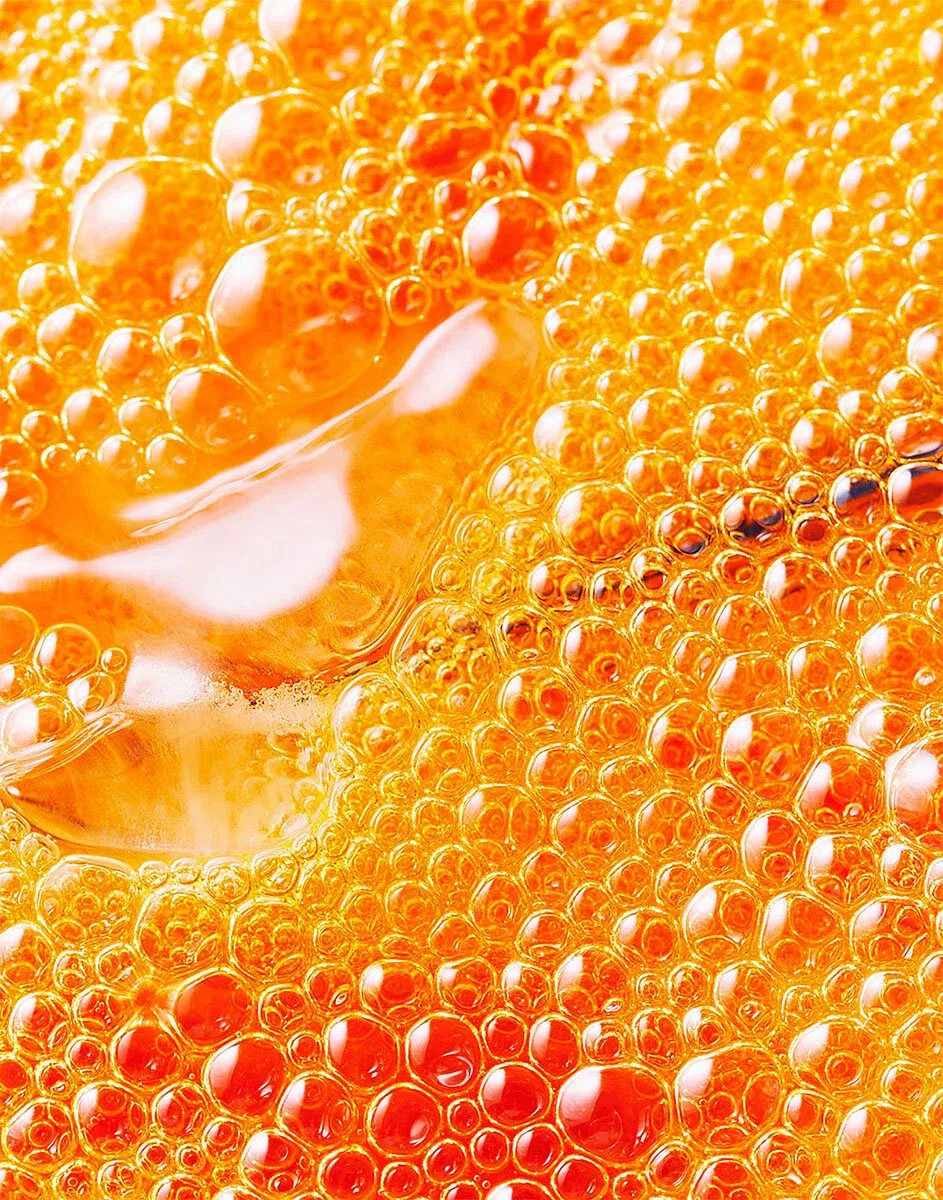  Close-up of orange liquid with bubbles, an abstract detail shot of a fizzy beverage.