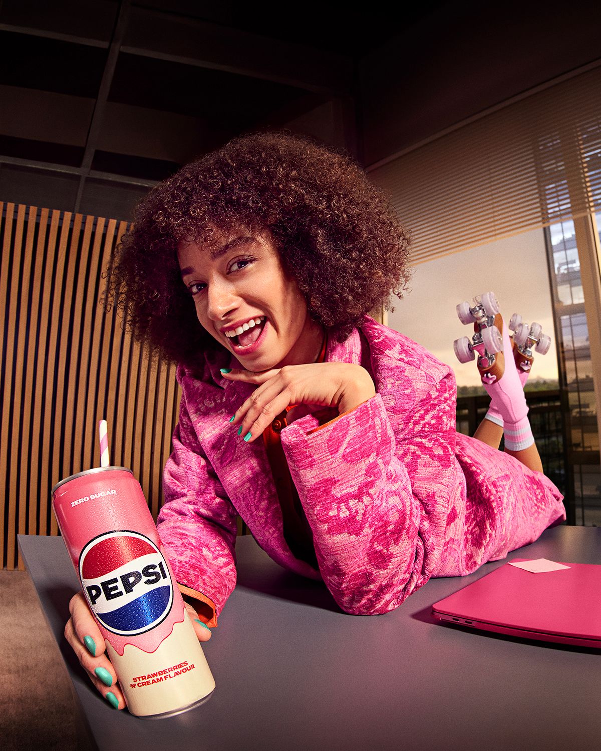 Woman in a pink jacket lies on a desk in roller skates, 